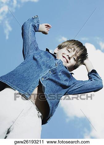 Low angle view of a boy with his arms raised View Large Photo Image Stock Image - Low angle view of a boy with his arms raised. Fotosearch