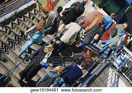 Stock Image - Low angle view of a group of people walking up stairs. Fotosearch