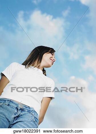 Stock Image - Low angle view of a teenage girl looking sideways. Fotosearch