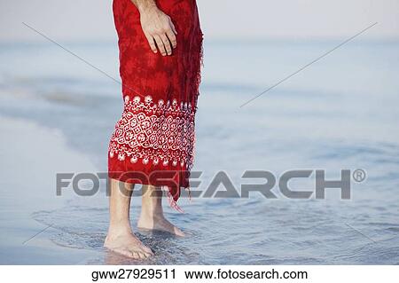 Low section view of a man standing on the beach View Large Photo Image Stock Image - Low section view of a man standing on the beach. Fotosearch