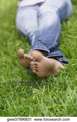 Low section view of a woman sitting on the grass View Large Photo Image Stock Image - Low section view of a woman sitting on the grass. Fotosearch