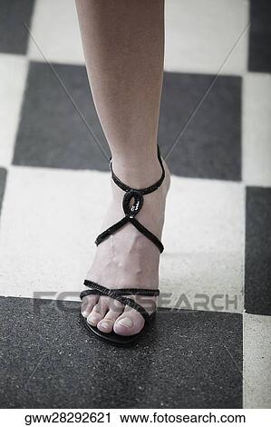 Low section view of a woman wearing a sandal View Large Photo Image Stock Image - Low section view of a woman wearing a sandal. Fotosearch