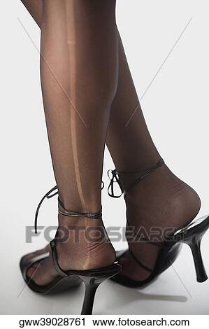 Low section view of a woman wearing high heels View Large Photo Image Stock Image - Low section view of a woman wearing high heels. Fotosearch