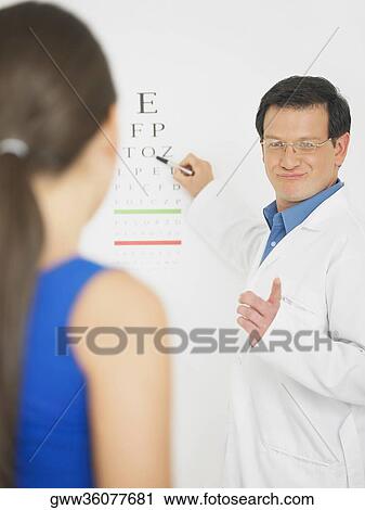 Male doctor doing an eye exam of a female patient View Large Photo Image Stock Image - Male doctor doing an eye exam of a female patient. Fotosearch