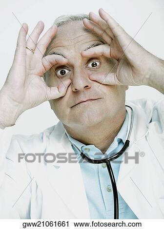 Male doctor pretending to wear glasses View Large Photo Image Stock Image - Male doctor pretending to wear glasses. Fotosearch
