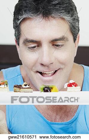 Mature man looking at pastries View Large Photo Image Stock Image - Mature man looking at pastries. Fotosearch
