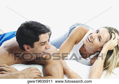 Mid adult couple lying on the bed and smiling View Large Photo Image Stock Image - Mid adult couple lying on the bed and smiling. Fotosearch