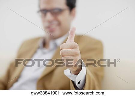 Stock Image - mid adult man giving a thumbs up sign. Fotosearch