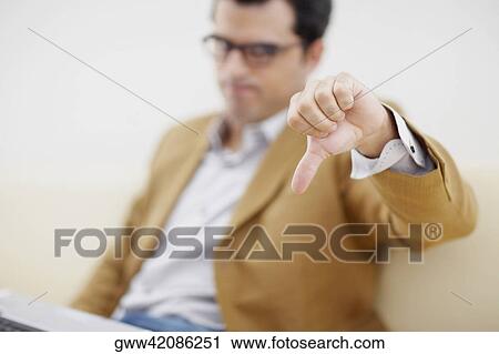 Mid adult man making a thumbs down sign View Large Photo Image Stock Image - Mid adult man making a thumbs down sign. Fotosearch