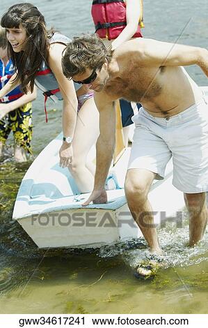 Mid adult man pulling a boat with his daughter standing in it View Large Photo Image Stock Image - Mid adult man pulling a boat with his daughter standing in it. Fotosearch