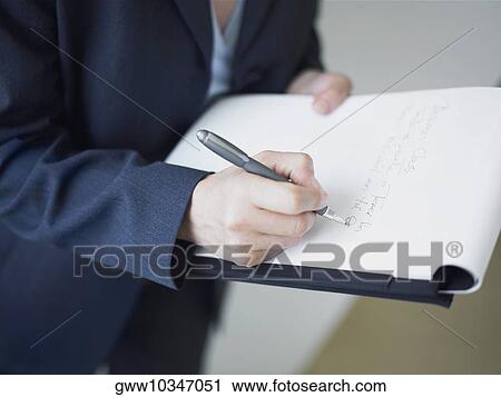 Mid section view of a businesswoman writing on a notepad View Large Photo Image Stock Image - Mid section view of a businesswoman writing on a notepad. Fotosearch