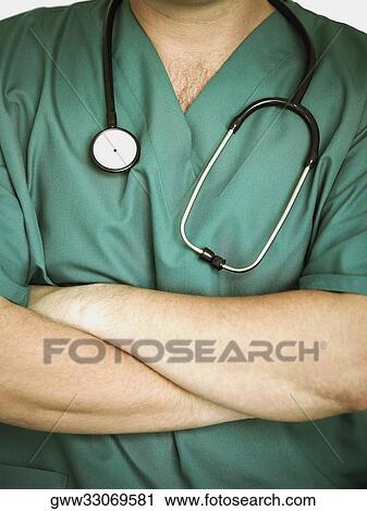 Stock Image - Mid section view of a male doctor with a stethoscope around his neck. Fotosearch