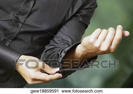 Mid section view of a man buttoning his cuff View Large Photo Image Stock Image - Mid section view of a man buttoning his cuff. Fotosearch