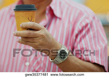 Mid section view of a man holding a disposable cup View Large Photo Image Stock Image - Mid section view of a man holding a disposable cup. Fotosearch
