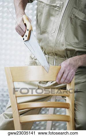 Mid section view of a man sawing a chair View Large Photo Image Stock Image - Mid section view of a man sawing a chair. Fotosearch