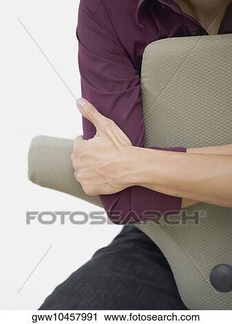 Mid section view of a man sitting in an armchair View Large Photo Image Stock Image - Mid section view of a man sitting in an armchair. Fotosearch