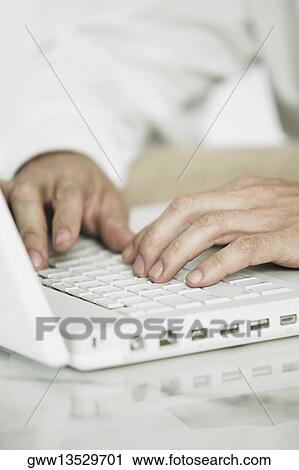Mid section view of a man using a laptop View Large Photo Image Stock Image - Mid section view of a man using a laptop. Fotosearch