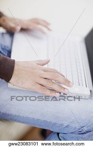 Mid section view of a man using a laptop View Large Photo Image Stock Image - Mid section view of a man using a laptop. Fotosearch