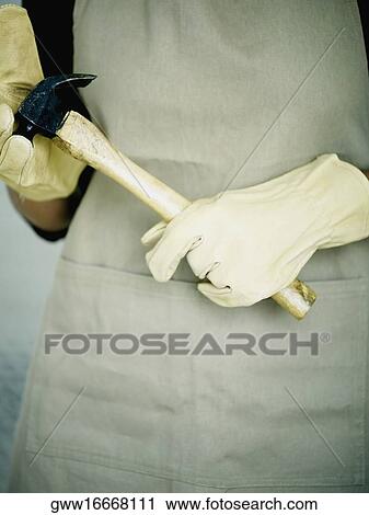 Mid section view of a person holding a hammer View Large Photo Image Stock Image - Mid section view of a person holding a hammer. Fotosearch