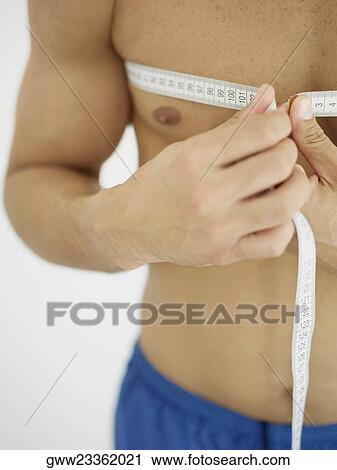 Mid section view of a person measuring his chest with a tape measure View Large Photo Image Stock Image - Mid section view of a person measuring his chest with a tape measure. Fotosearch
