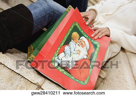 Mid section view of a woman sitting on steps with shopping bags View Large Photo Image Stock Image - Mid section view of a woman sitting on steps with shopping bags. Fotosearch