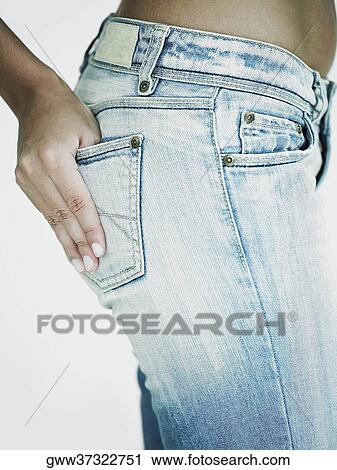 Mid section view of a woman with her hand in her jeans pocket View Large Photo Image Stock Image - Mid section view of a woman with her hand in her jeans pocket. Fotosearch