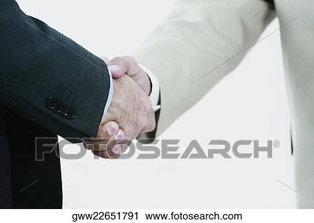 Mid section view of two businessmen shaking hands View Large Photo Image Stock Image - Mid section view of two businessmen shaking hands. Fotosearch