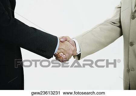 Mid section view of two businessmen shaking hands View Large Photo Image Stock Image - Mid section view of two businessmen shaking hands. Fotosearch