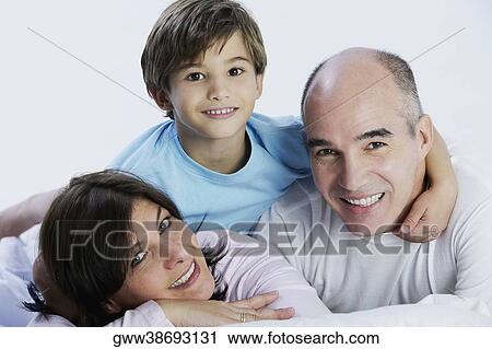Portrait of a boy and his parents lying on the bed View Large Photo Image Stock Image - Portrait of a boy and his parents lying on the bed. Fotosearch