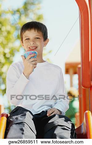 Stock Image - Portrait of a boy holding an ice-cream cone. Fotosearch