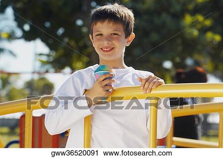 Portrait of a boy holding an ice-cream and smiling View Large Photo Image Stock Image - Portrait of a boy holding an ice-cream and smiling. Fotosearch