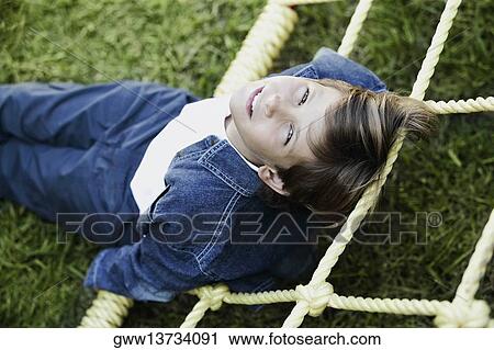 Portrait of a boy lying in a garden View Large Photo Image Stock Image - Portrait of a boy lying in a garden. Fotosearch