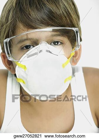 Stock Image - Portrait of a boy wearing a pollution mask. Fotosearch