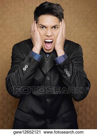 Portrait of a businessman shouting and covering his ears with his hands View Large Photo Image Stock Image - Portrait of a businessman shouting and covering his ears with his hands. Fotosearch