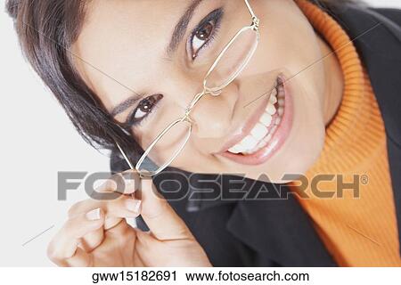 Portrait of a businesswoman adjusting her eyeglasses and smiling View Large Photo Image Stock Image - Portrait of a businesswoman adjusting her eyeglasses and smiling. Fotosearch