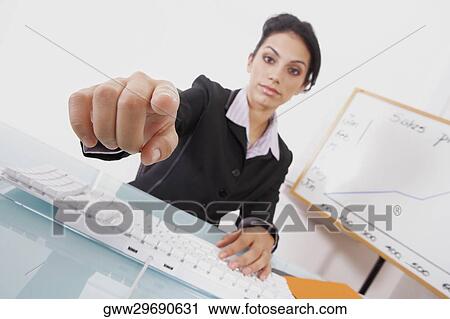 Portrait of a businesswoman using a computer keyboard and pointing forward View Large Photo Image Stock Image - Portrait of a businesswoman using a computer keyboard and pointing forward. Fotosearch