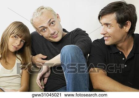 Portrait of a father with his daughter and a young man sitting beside them View Large Photo Image Stock Image - Portrait of a father with his daughter and a young man sitting beside them. Fotosearch