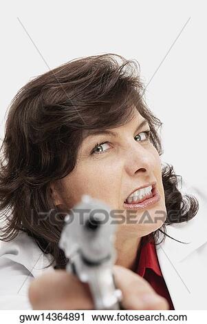 Stock Image - Portrait of a female doctor holding a handgun. Fotosearch