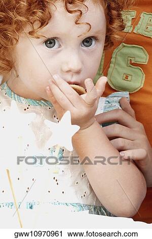 Portrait of a girl eating a biscuit View Large Photo Image Stock Image - Portrait of a girl eating a biscuit. Fotosearch