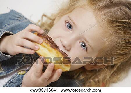 Portrait of a girl eating a cake View Large Photo Image Stock Image - Portrait of a girl eating a cake. Fotosearch