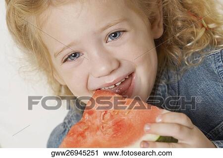 Portrait of a girl eating a slice of watermelon and smiling View Large Photo Image Stock Image - Portrait of a girl eating a slice of watermelon and smiling. Fotosearch