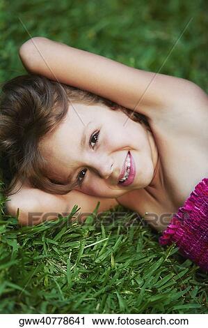 Portrait of a girl lying on the grass and smiling View Large Photo Image Stock Image - Portrait of a girl lying on the grass and smiling. Fotosearch