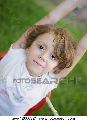 Stock Image - Portrait of a girl on a swing. Fotosearch