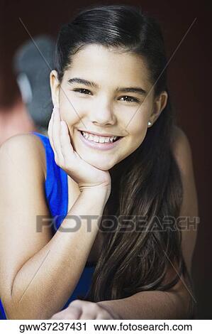 Portrait of a girl smiling with her hand on her chin View Large Photo Image Stock Image - Portrait of a girl smiling with her hand on her chin. Fotosearch
