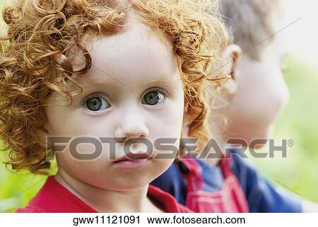 Stock Image - Portrait of a girl with a boy beside her. Fotosearch