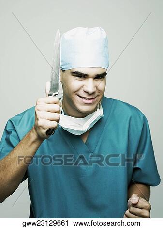 Stock Image - Portrait of a male surgeon holding a knife. Fotosearch