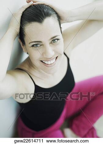 Stock Image - Portrait of a mature woman smiling with her hands behind her head. Fotosearch