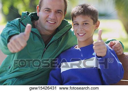 Portrait of a mid adult man and his son giving thumbs up sign View Large Photo Image Stock Image - Portrait of a mid adult man and his son giving thumbs up sign. Fotosearch