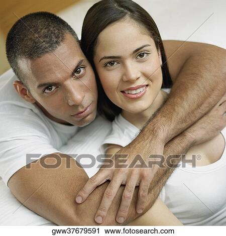 Portrait of a mid adult man embracing a young woman from behind View Large Photo Image Stock Image - Portrait of a mid adult man embracing a young woman from behind. Fotosearch
