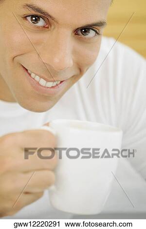 Portrait of a mid adult man holding a cup of tea and smiling View Large Photo Image Stock Image - Portrait of a mid adult man holding a cup of tea and smiling. Fotosearch